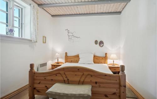1 dormitorio con cama de madera y silla en Mlletoften, en Thyholm