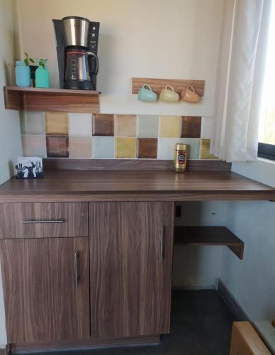 a wooden desk with a coffee maker on top of it at Tres Velas Surf in Celestino Gasca