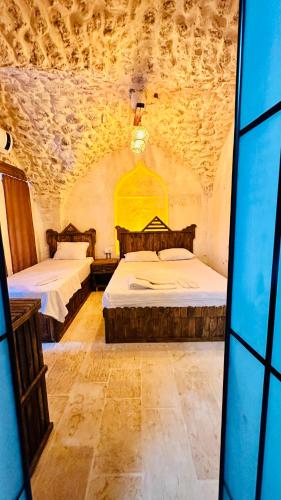 a room with two beds in a stone room at Serce Konagi in Urfa