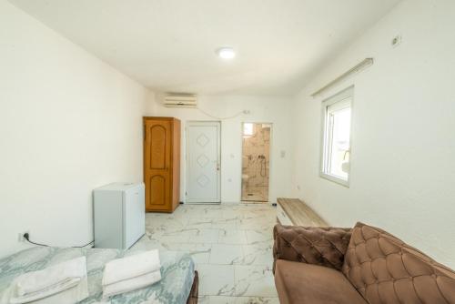 een woonkamer met een bank en een deur bij Apartmani Medovic in Ulcinj
