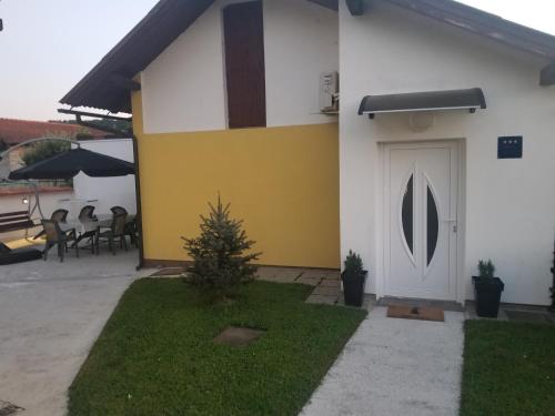 a white and yellow house with a white door at Soba - Room - Zimmer M in Karlovac