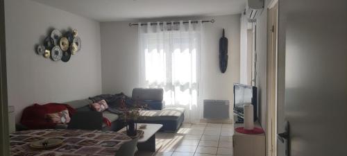 eine Person, die auf einer Couch im Wohnzimmer liegt in der Unterkunft Résidence les tonneliers in Mèze