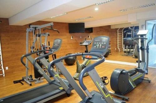 a gym with several treadmills and exercise bikes at Flat em frente a praia Macaé in Macaé