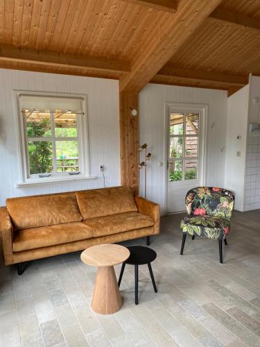 a living room with a couch and a chair at De Weide - Camping Botniahiem - Damwoude in Dantumawoude