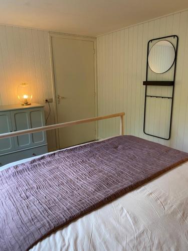 a bedroom with a bed with a purple blanket at De Weide - Camping Botniahiem - Damwoude in Dantumawoude
