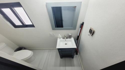 a bathroom with a sink and a toilet and a mirror at New Town Condo Casamar 3 near the beach in Puerto Peñasco