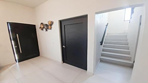 a room with a black door and stairs at New Town Condo Casamar 3 near the beach in Puerto Peñasco