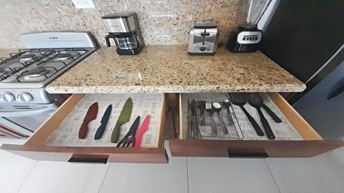 a kitchen counter with a counter top with knives in a drawer at New Town Condo Casamar 3 near the beach in Puerto Peñasco