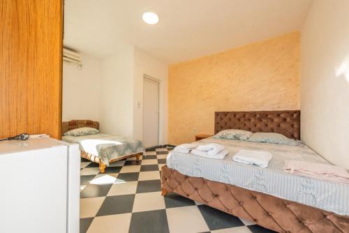 een slaapkamer met 2 bedden en een geruite vloer bij Apartmani Medovic in Ulcinj