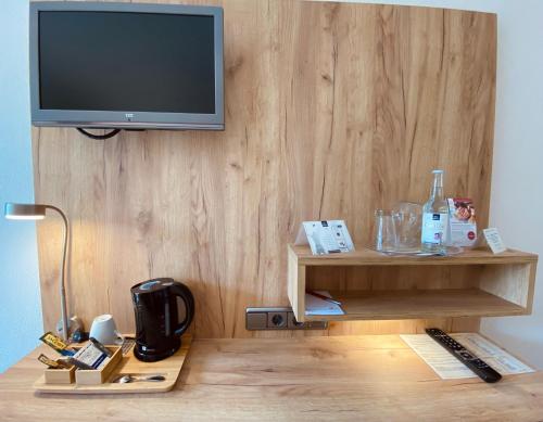 a room with a television on a wooden wall at Hotel Sonnenhügel in Bad Bevensen