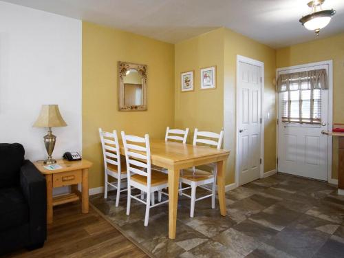 a dining room with a wooden table and chairs at Green Gables Motel & Suites in Burney