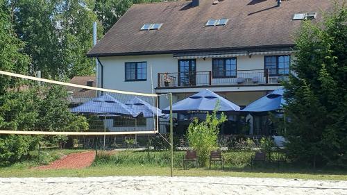 ein Haus mit blauen Sonnenschirmen davor in der Unterkunft Laguna House in Līči