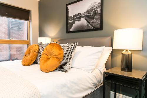 una camera da letto con un letto con cuscini arancioni sopra di Ancoats House a Manchester