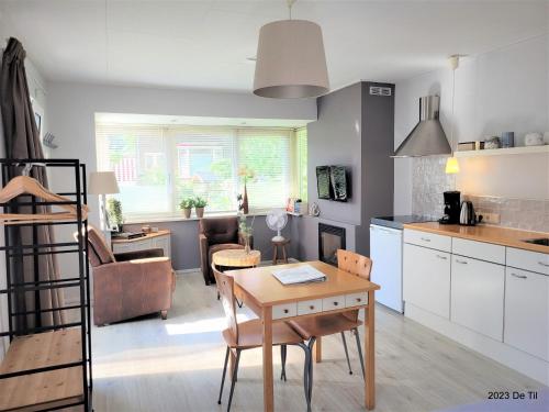 De Til Heelsum في هيلسوم: مطبخ وغرفة معيشة مع طاولة وغرفة طعام