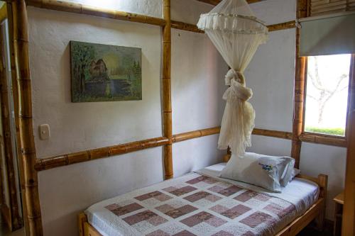 - une chambre avec un lit avec un rideau et une fenêtre dans l'établissement CABAÑA FAMILIAR en EcoparqueChinauta, PISCINA, GRANJA, JUEGOS, PESCA, RESTAURANTE, à Fusagasuga
