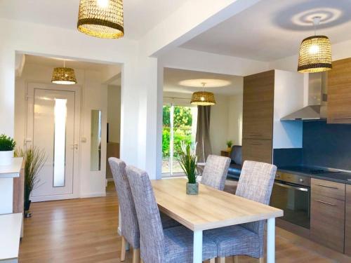 a kitchen and dining room with a table and chairs at Caporizon-Villa Courant-Terrasse-Proche Plage in Mimizan