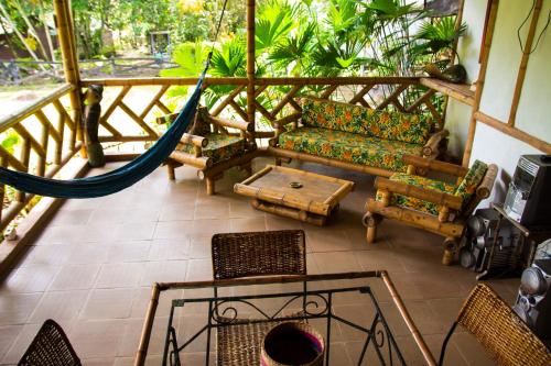 a living room with a hammock and chairs at CABAÑA FAMILIAR en EcoparqueChinauta, PISCINA, GRANJA, JUEGOS, PESCA, RESTAURANTE in Fusagasuga