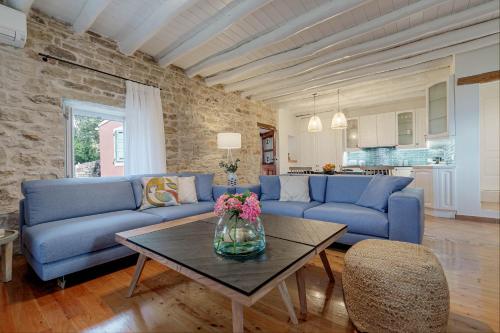 a living room with blue couches and a table at Villa Aurora Paxos in Anemogiannátika