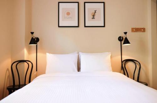 sypialnia z dużym białym łóżkiem z 2 lampami w obiekcie Dancing Bear Inn Hostel w mieście Nelson