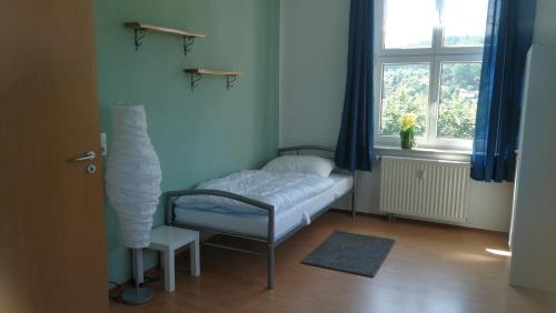 Habitación pequeña con cama y ventana en Ferienwohnung Sonnenblick, en Burkhardtsdorf