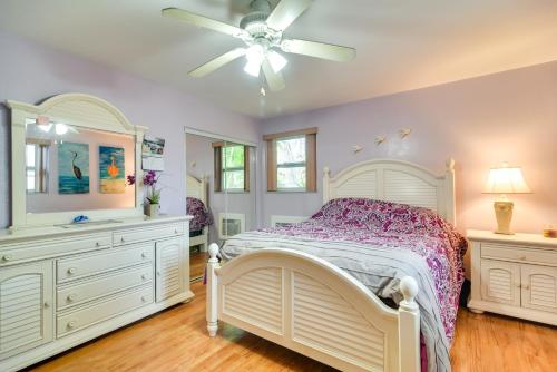 1 dormitorio con cama blanca y ventilador de techo en Sunny Florida Escape - Patio and Grill, Near Beaches en St Pete Beach