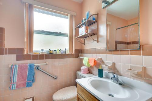 a bathroom with a sink and a mirror and a toilet at Sunny Florida Escape - Patio and Grill, Near Beaches in St Pete Beach