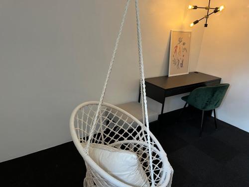 een witte schommelstoel in een kamer met een bureau bij 120 kvm lejlighed med have i kælderniveau in Tølløse