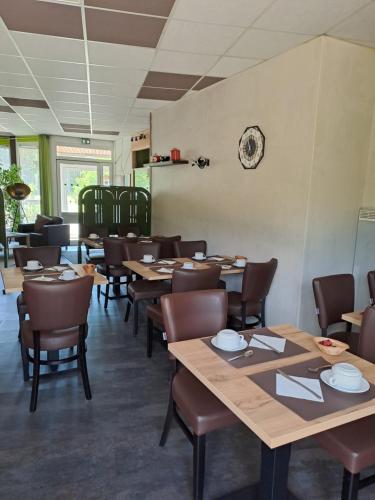 a dining room with wooden tables and chairs at Hôtel Le Grand Chêne in Gièvres