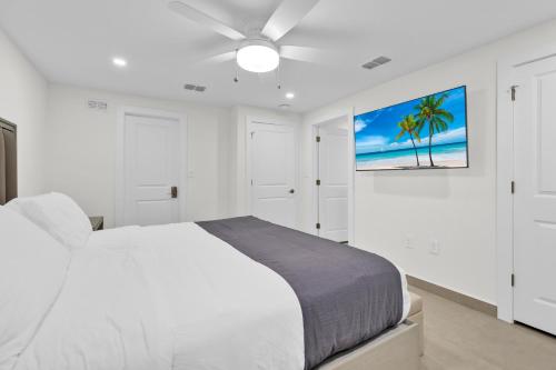 a white bedroom with a bed and a ceiling fan at Large Family Luxury Beachfront Condo, Private Terrace & Pool in South Padre Island