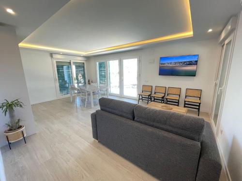 Apartamentos Luxury Mazagón في بالوس دي لا فرونتيرا: غرفة معيشة مع أريكة وطاولة