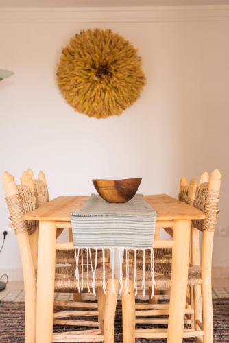 a wooden table with chairs and a bowl on top at Jnane Allia in Douar Soukkane