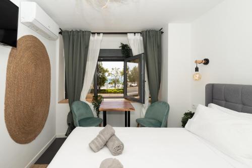 1 dormitorio con 1 cama, 2 sillas y ventana en El Mirador, en Alicante