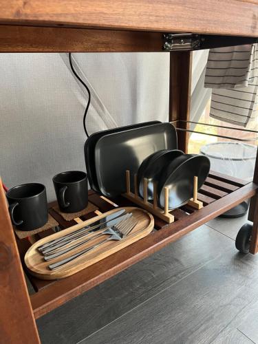a table with plates and utensils on a shelf at Skywoods.glamping in Molėtai