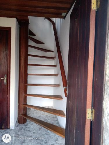 a spiral staircase in a room with a wooden door at Pousada Nova Conquista in Penedo