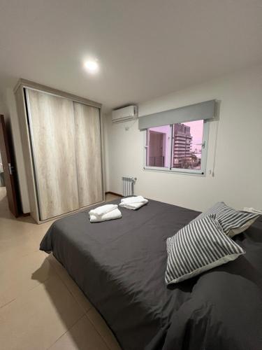 a bedroom with a large bed with two towels on it at Apartamento a metros de la costanera y el lago in Villa María