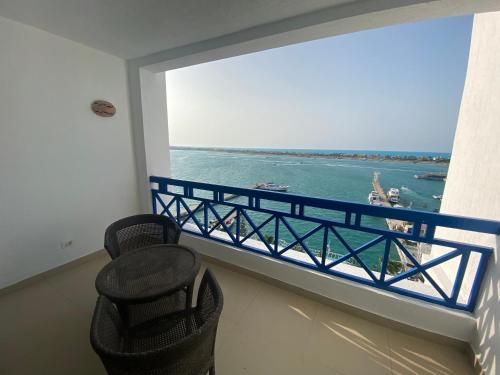 a balcony with chairs and a view of the water at Executive Royal Tower Apartments - Sky Lounge in El Alamein