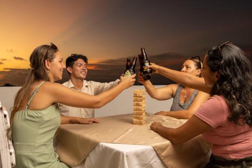 Un groupe de personnes assises autour d'une table en train de boire de la bière dans l'établissement Galapagos Planet Hotel, à Puerto Baquerizo Moreno