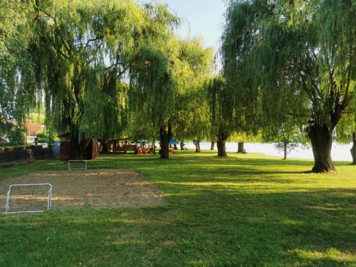 a park with trees and a soccer ball on the grass at Tótündér Vendégház in Levelek