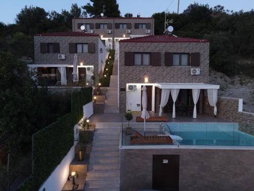 a villa with a swimming pool at night at Four Princess in Agia Paraskevi