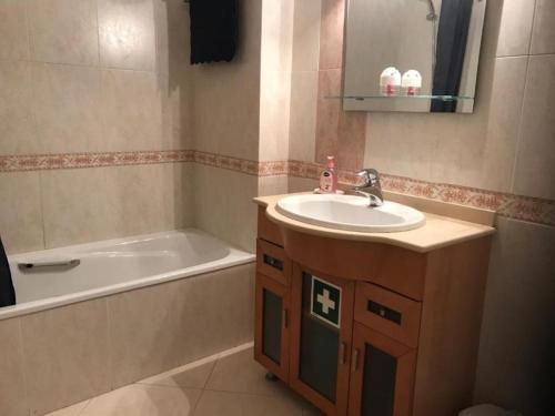 a bathroom with a sink and a bath tub at Vila Marachique V Alvor in Alvor