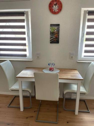 a dining room with a table and chairs and a clock at Apartment Mirabelle 4 in Püttlingen