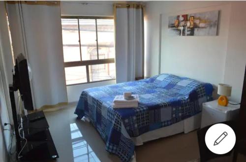 una camera con un letto blu e una finestra di wilsonpedro a Iquique
