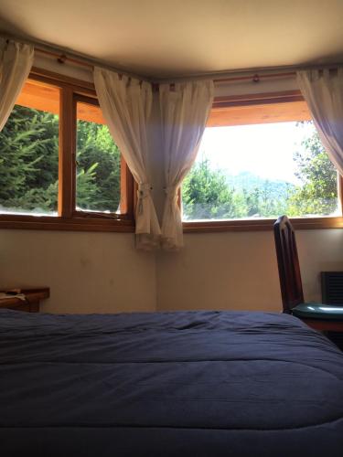 um quarto com uma cama e duas janelas em ABROJITOS em Villa La Angostura