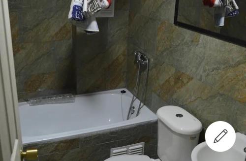 een badkamer met een bad, een toilet en een wastafel bij wilsonpedro in Iquique