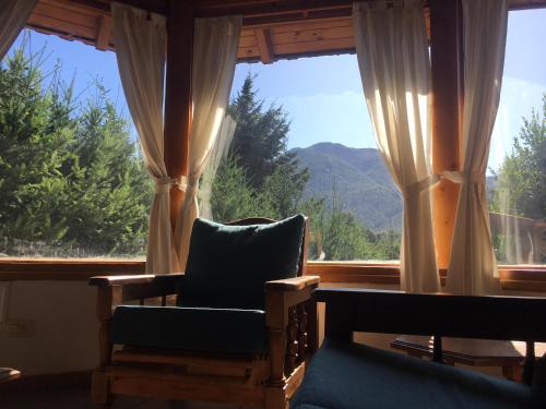 a room with two chairs and a window with mountains at ABROJITOS in Villa La Angostura