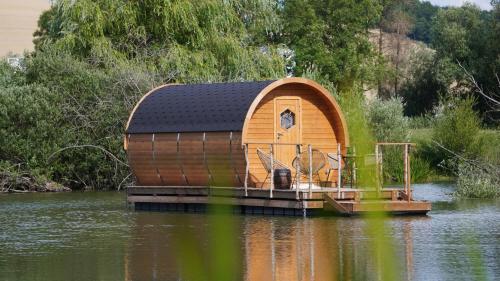 a small wooden house on a body of water at Les Cabanes Flottantes in Givrauval