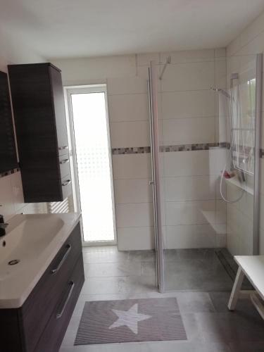 ein Badezimmer mit Dusche und Waschbecken in der Unterkunft Wellenbude in Otterndorf