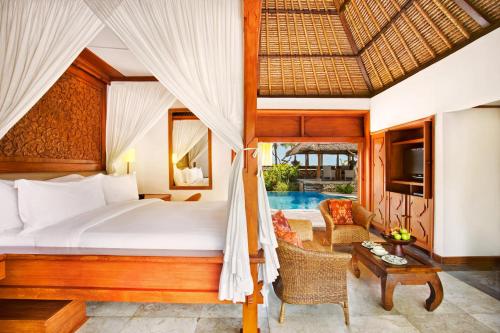 a bedroom in a villa with a bed and a table at The Oberoi Beach Resort, Bali in Seminyak