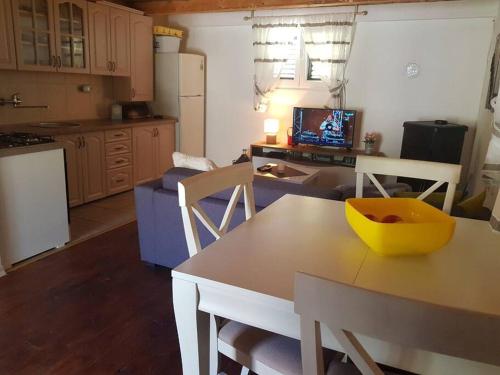 uma cozinha e sala de estar com mesa e cadeiras em Holiday home above the Bukumirsko Lake em Podgorica