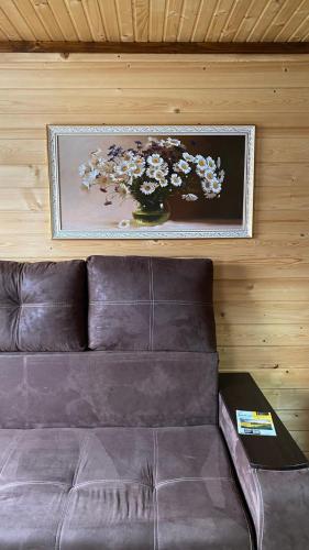 a couch with a vase of flowers on the wall at Котедж "Смерековий затишок" in Vorokhta